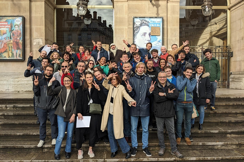 Medarbetare på RTE i Paris på trappan framför en husfasad.