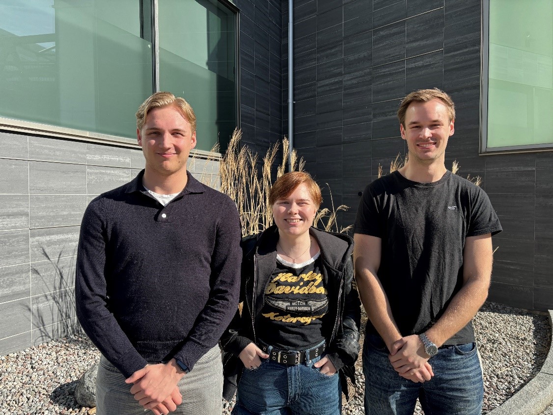 Linus, Ella och Lucas framför en byggnad.