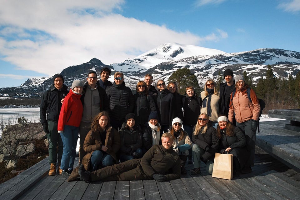 Traineerna poserar med fjälltoppar i bakgrunden.
