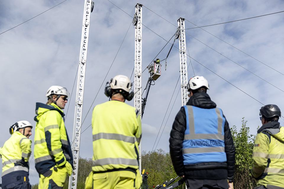 En grupp personer tittar på stolpar gjorda av aluminium