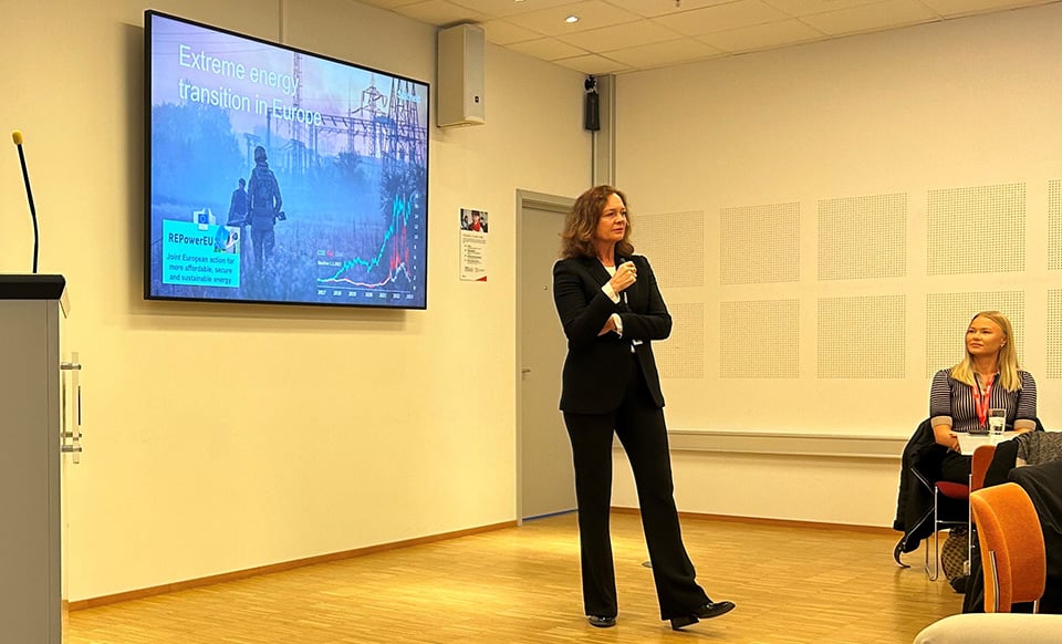 Kvinna står framför en tv och pratar i en mikrofon.