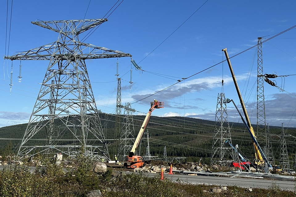 Kraftledningsstolpar och mobilkranar i fjällmiljö