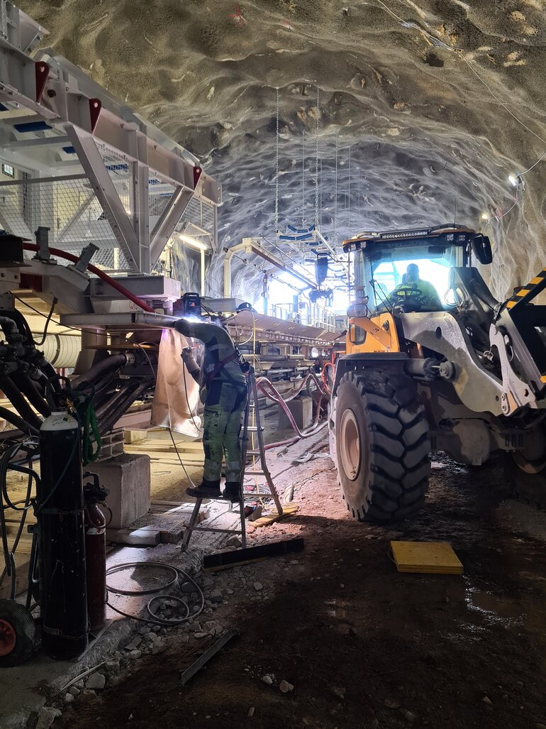 Byggarbete i tunnel och en grävmaskin