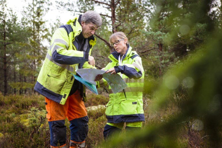 Bild på två fältarbetare i skogen