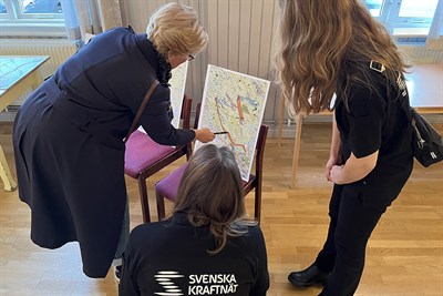 Markägare och personer från projektgruppen för Svartbyn -Hällmyran tittar på kartor tillsammans.