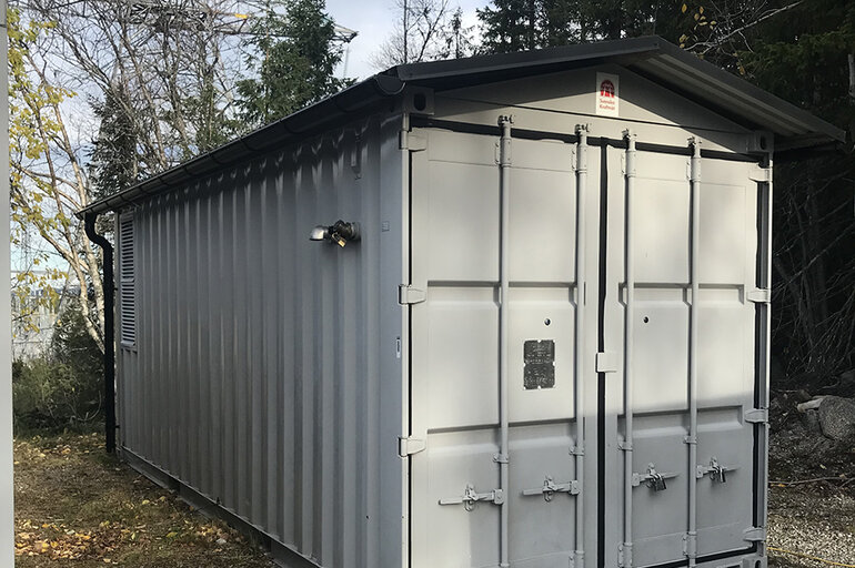 Vit liten byggnad i metall