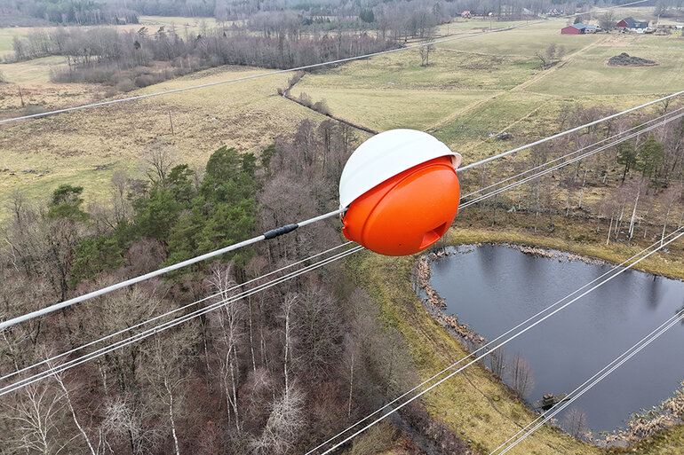 Bilden visar en flyghindermarkör, ett klot i rött och vitt