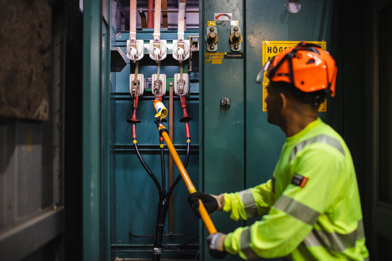 Man i varselväst som lagar elkabelcentral