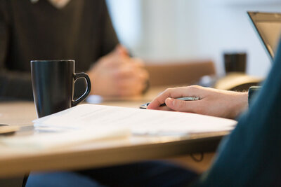 Bild på hand som håller i en penna och skriver på ett papper