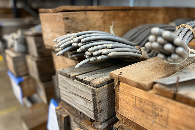 Närbild på trälådor som innehåller olika metalldelar